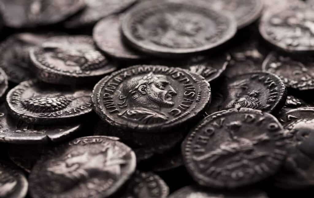 Close-up shot of coin of roman emperor Maximinus among other coins, selective focusing